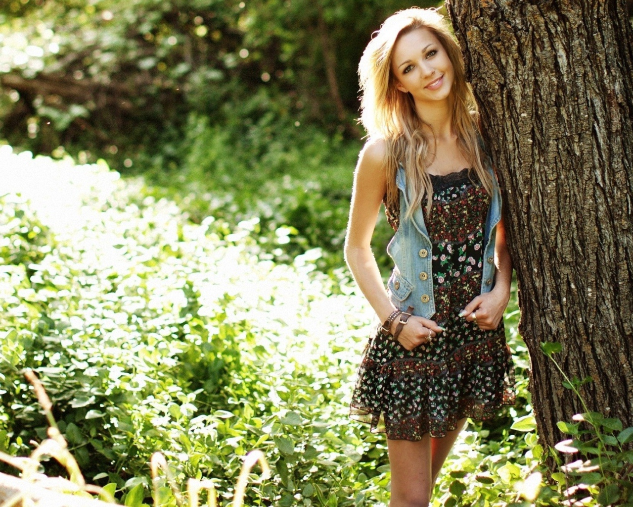 Милая блондинка прислонилась к дереву