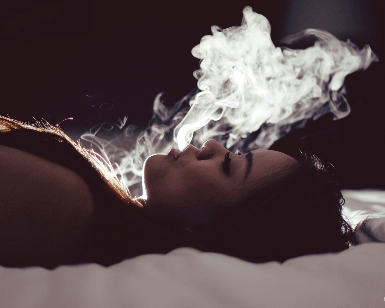 Девушка выпускает дым изо рта