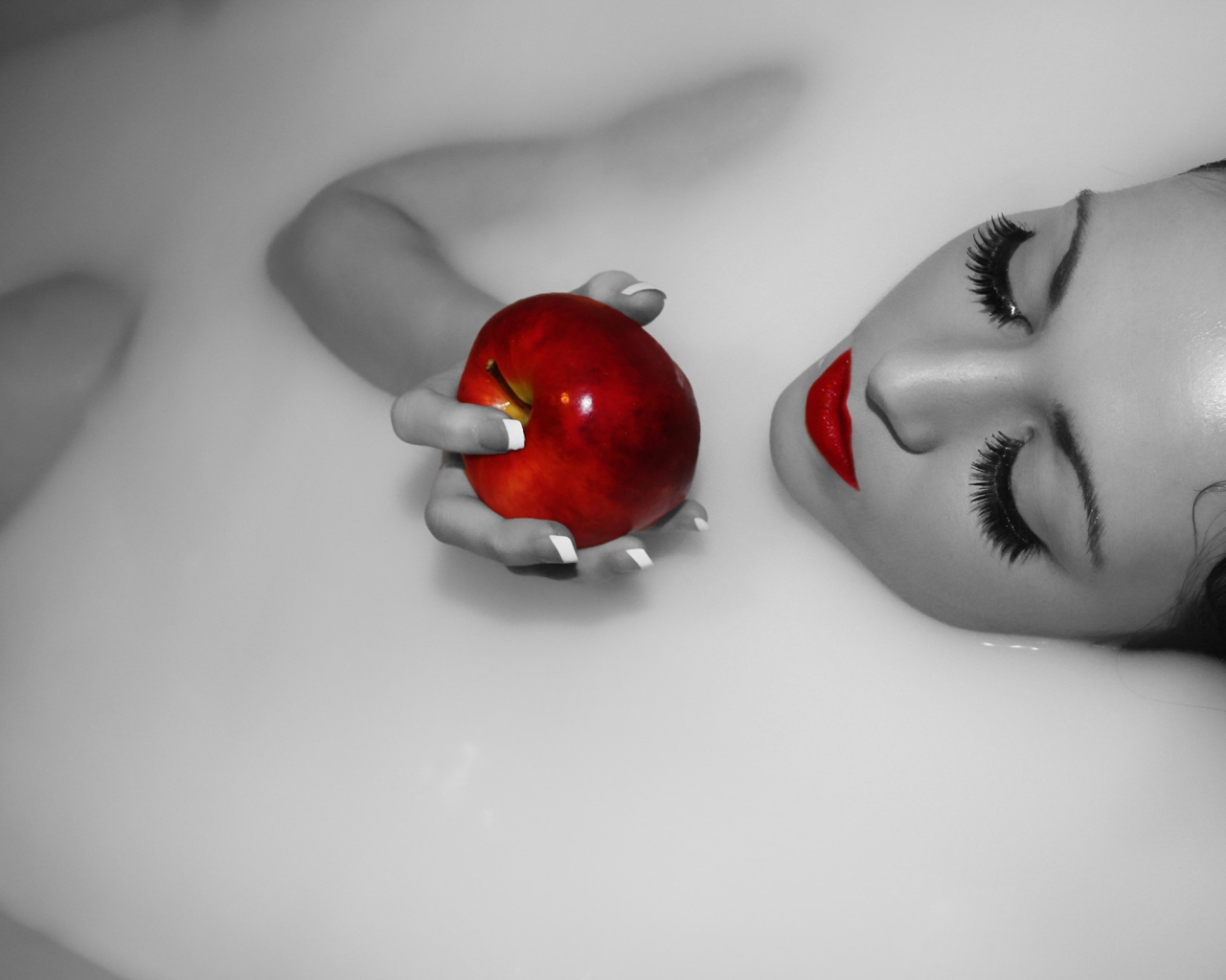 Девушка ест яблоко лежа в ванной