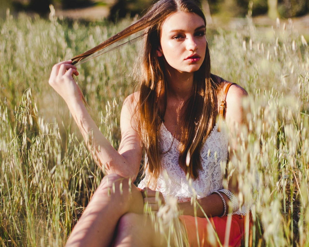 Девушка держит в руке прядь волос