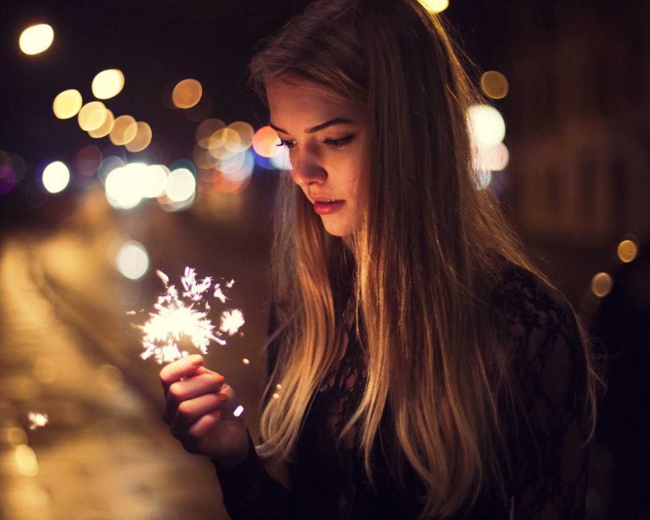Девушка держит в руке бенгальский огонь