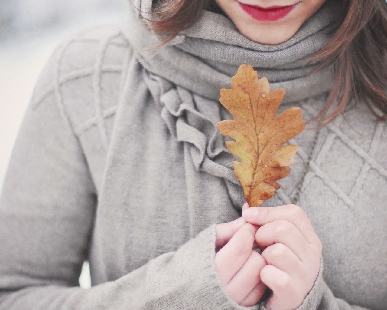 Девушка держит в руках желтый лист