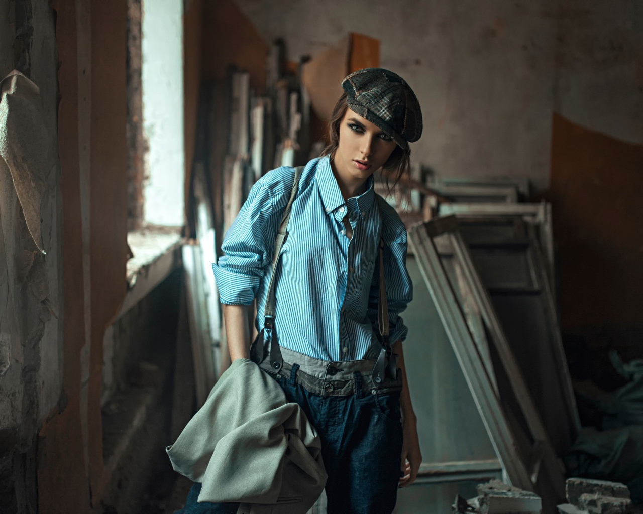 Девушка в берете стоит среди ремонта