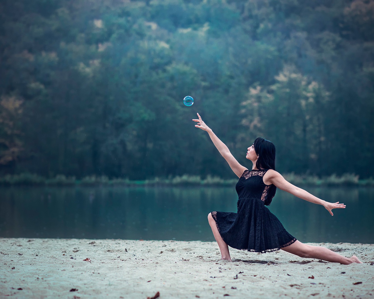 Девушка в черном платье и мыльный пузырь