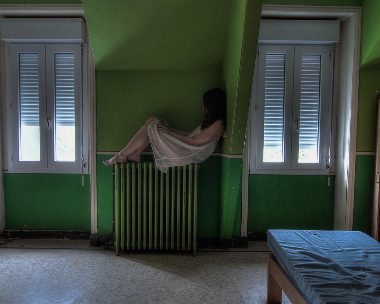 Девушка в ночной рубашке сидит на батарее