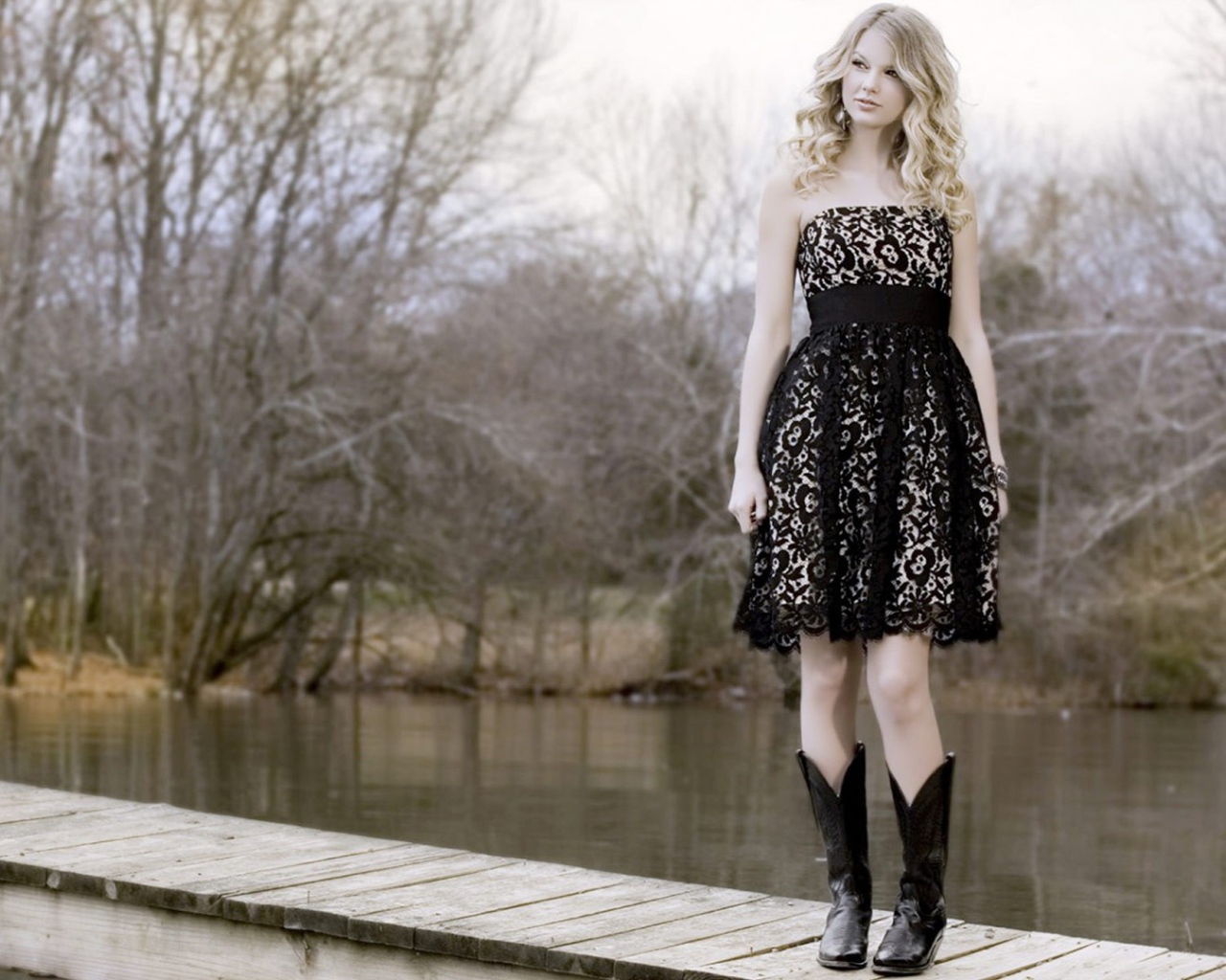 Девушка в черном платье и кожаных сапогах