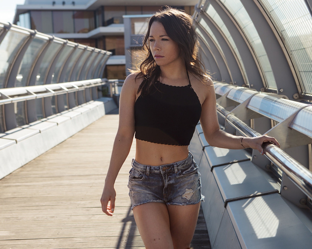 Девушка в джинсовых шортах на мосту