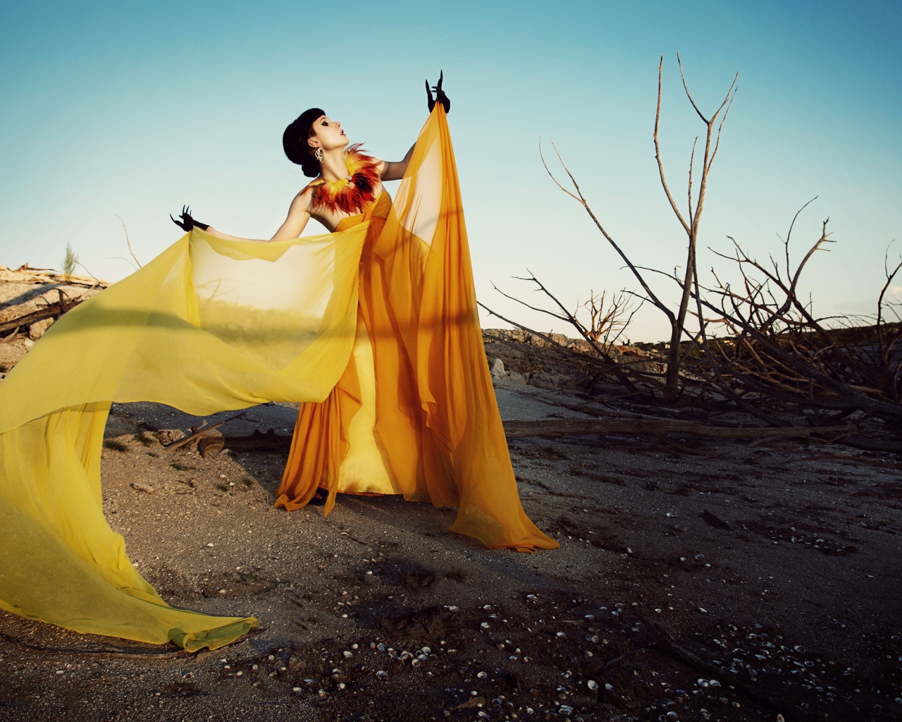 Девушка в оранжевом позирует в пустыне