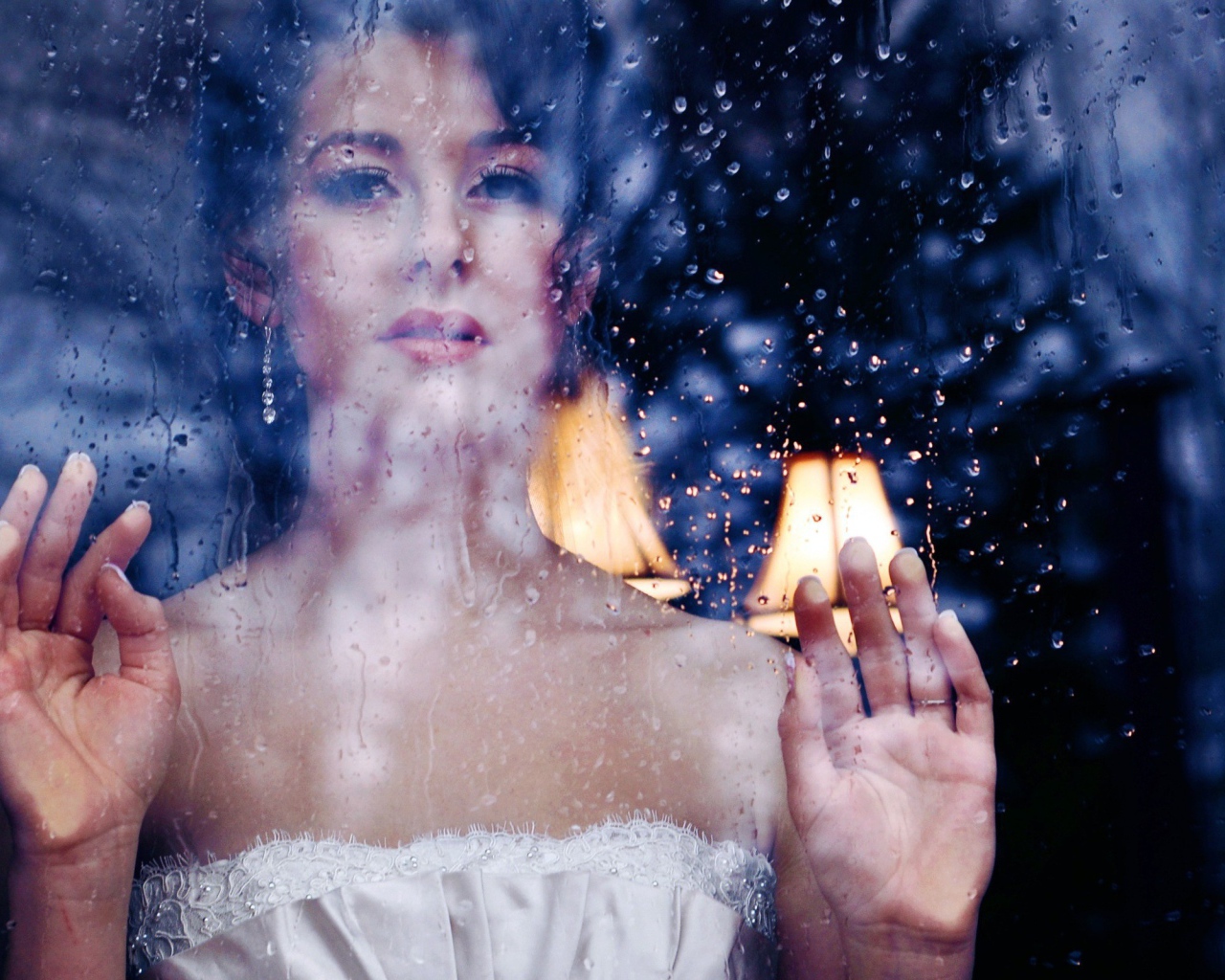 Девушка в белом платье за мокрым стеклом