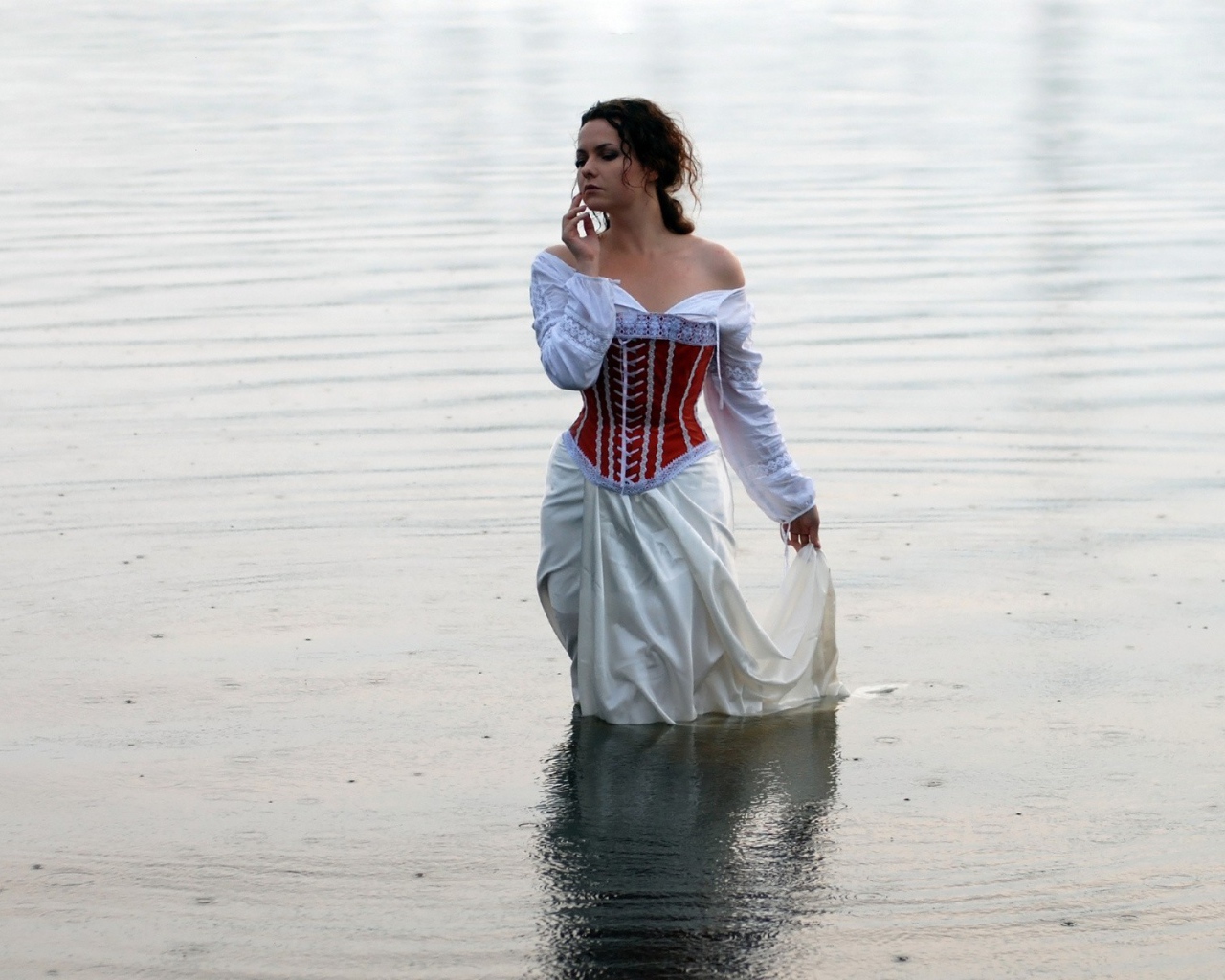 Девушка в белом платье стоит в воде