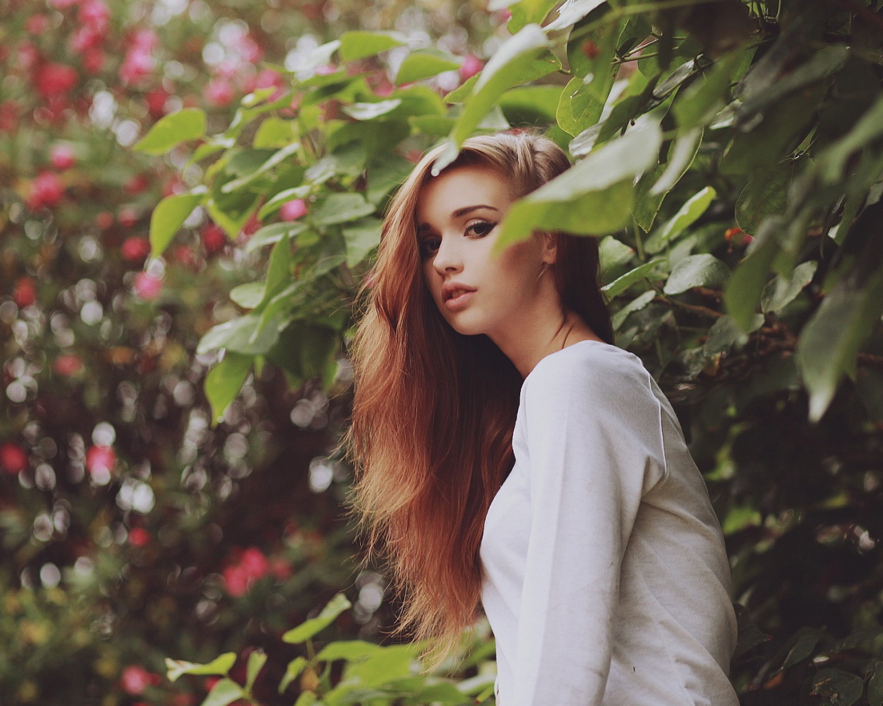 Девушка в белом платье гуляет в саду