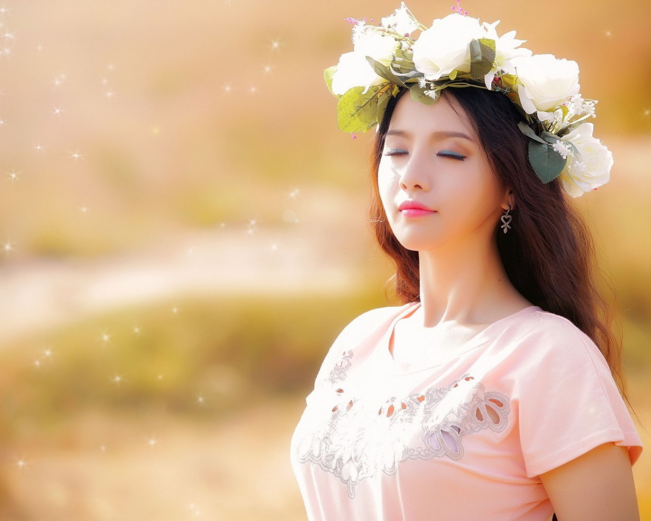 Девушка в белом венке прикрыла глаза