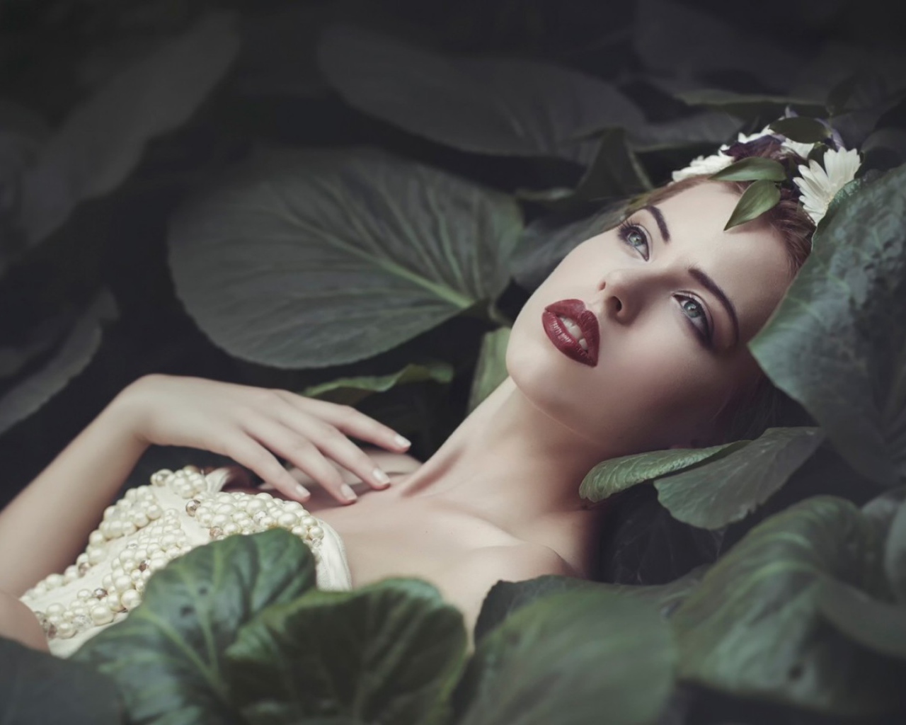 Девушка лежит в больших листьях