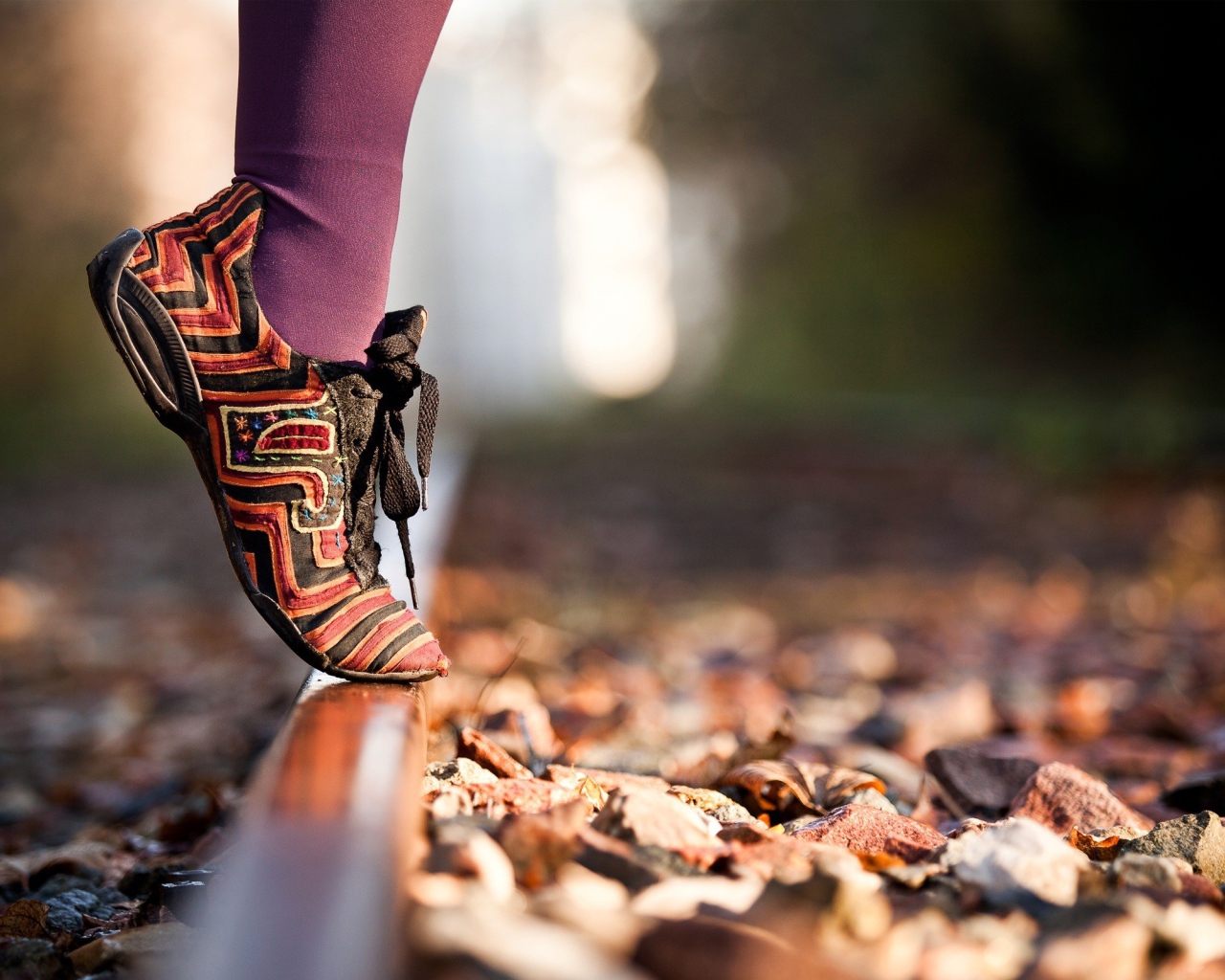 Девушка на носочках на рельсе