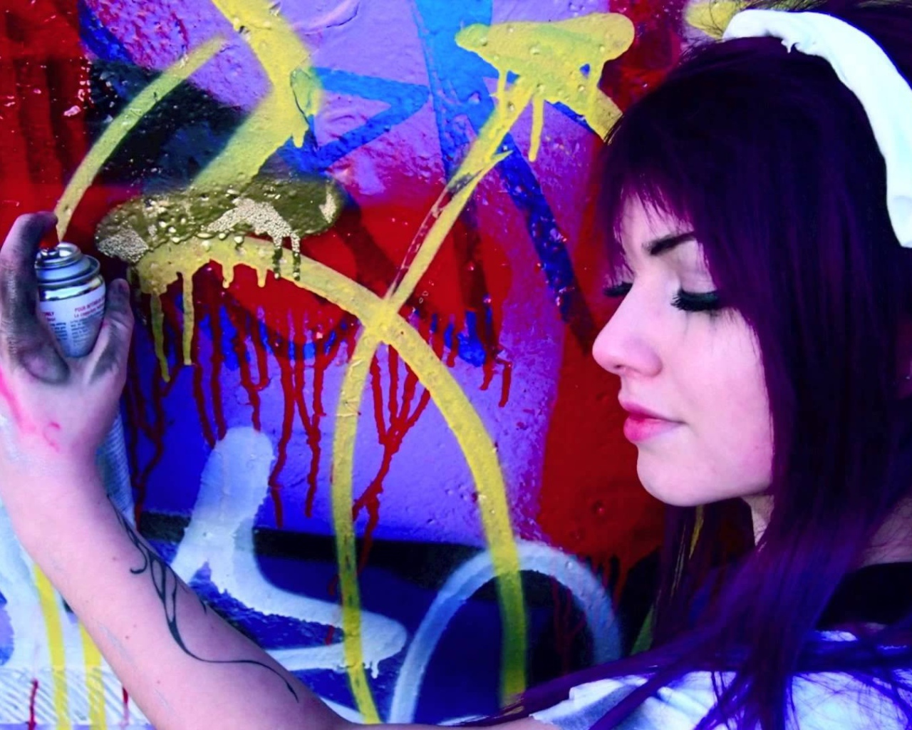 Девушка рисует граффити на стене