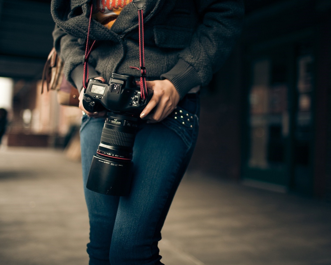 Девушка фотограф с профессиональным фотоаппаратом Canon