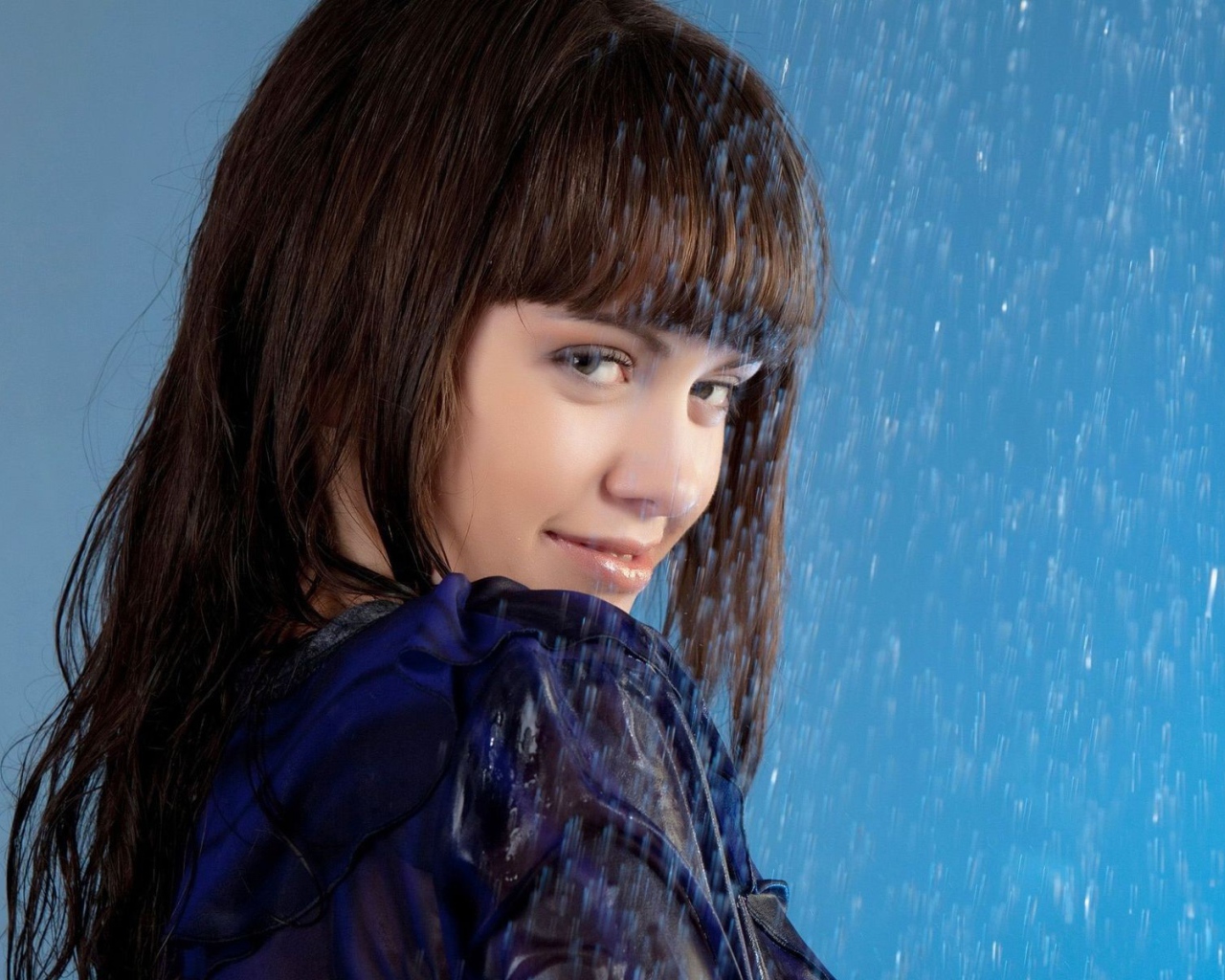 Девушка стоит под струей воды