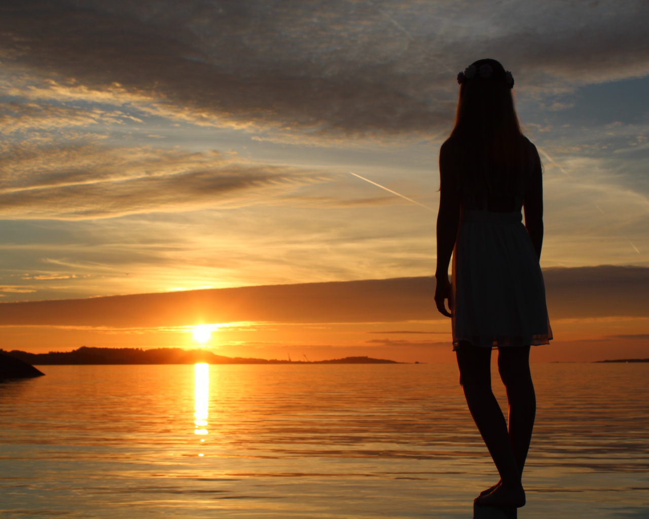 Девушка смотрит на закат в Норвегии