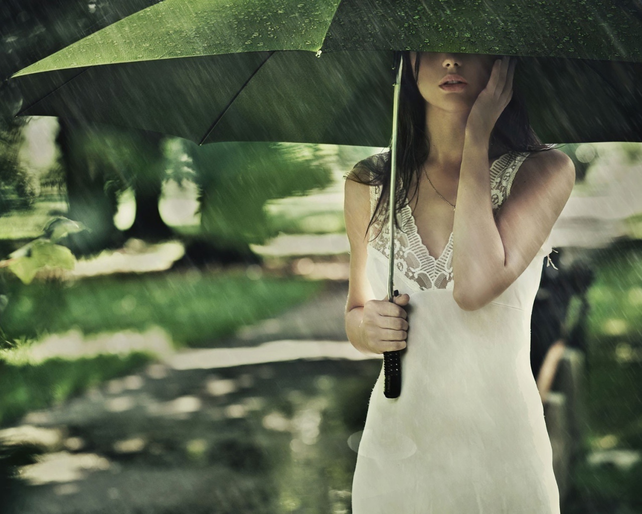 Девушка под зеленым зонтом во время дождя