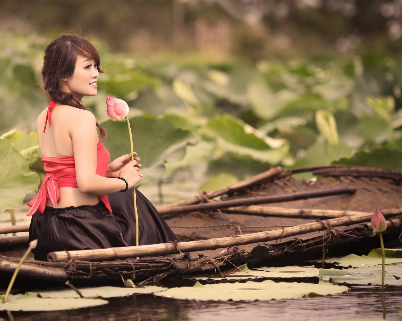 Girl with flower sitting in a boat