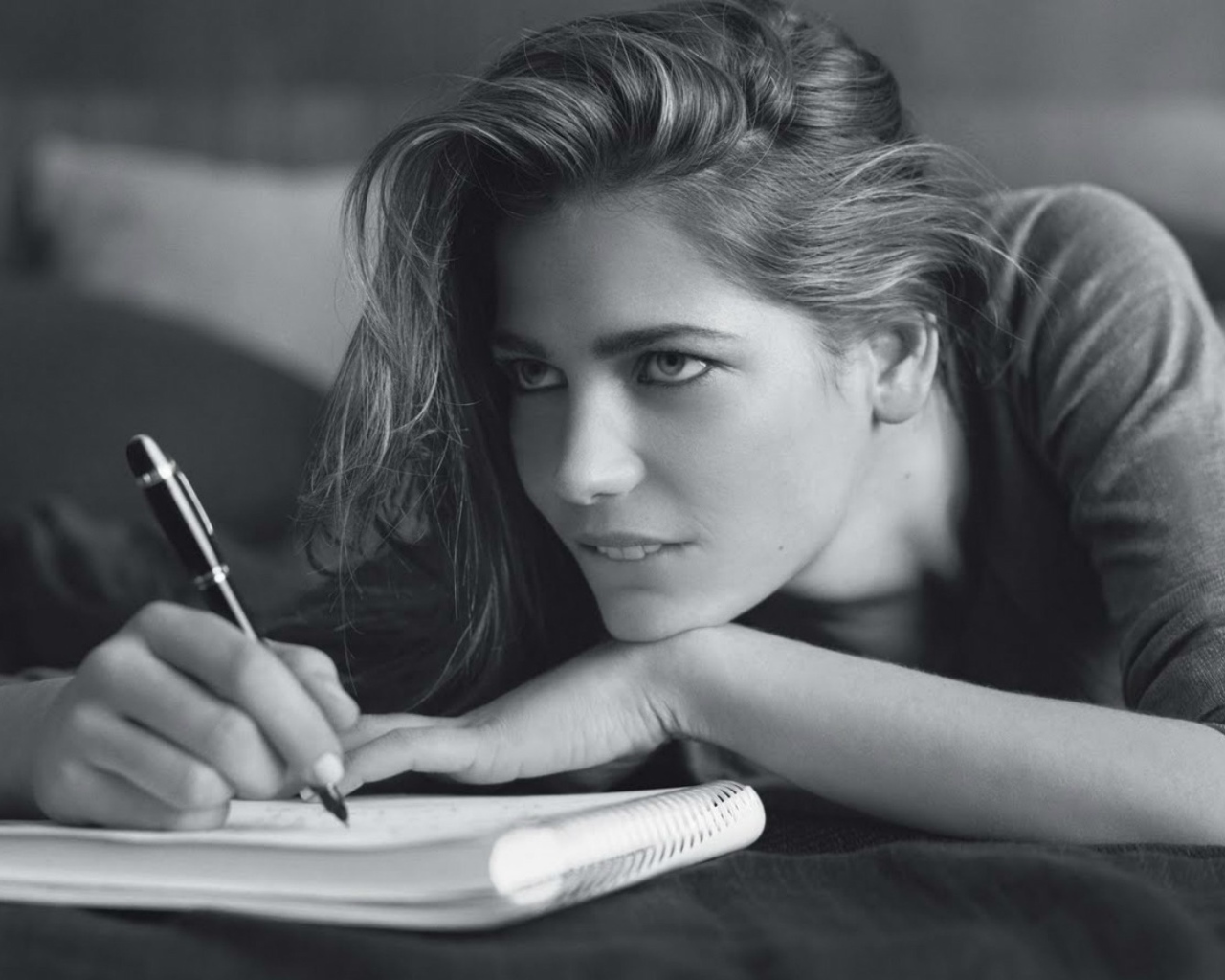 Девушка пишет в блокноте