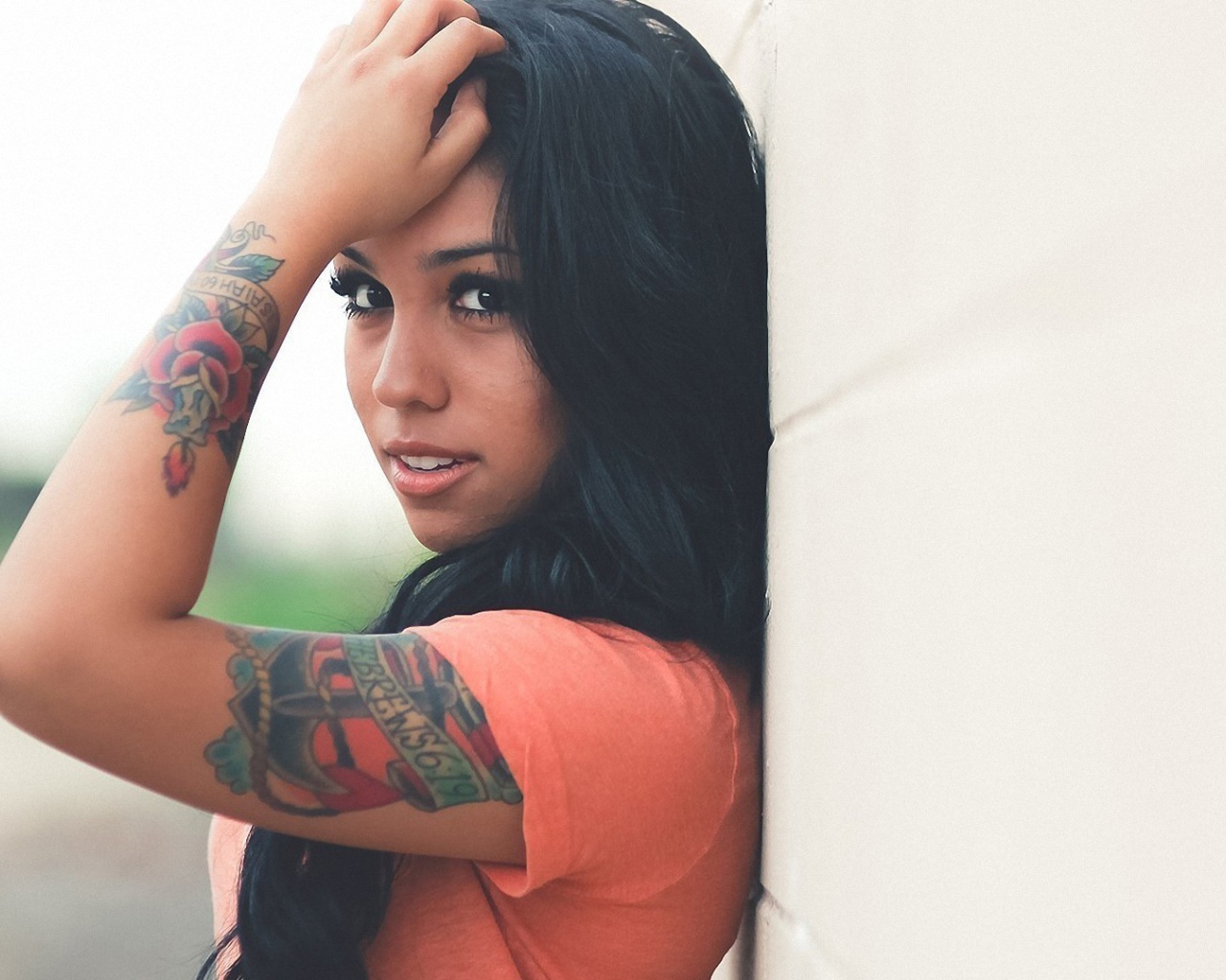 Страстная длинноволосая брюнетка прислонилась к стене