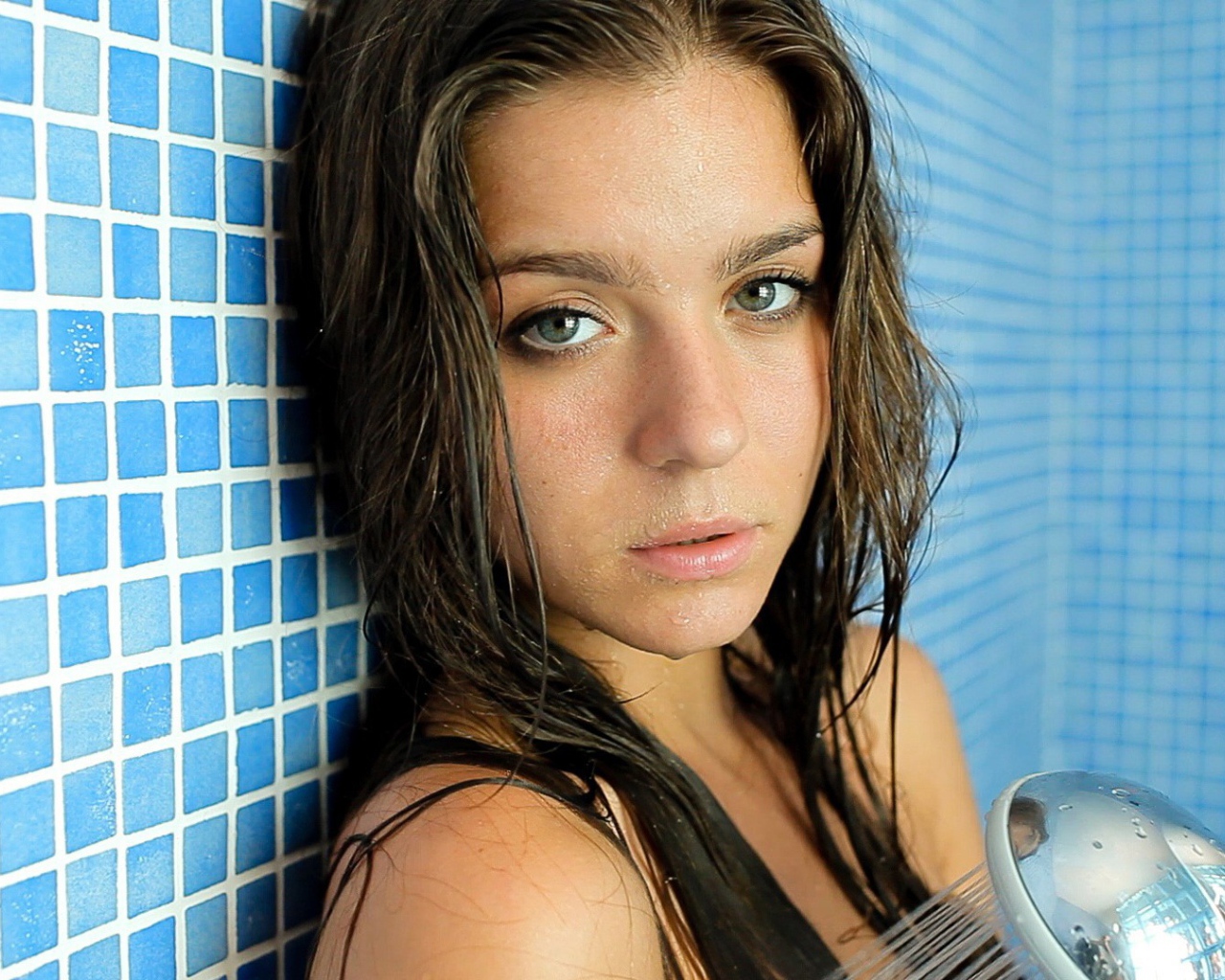 Зеленоглазая брюнетка стоит в душе