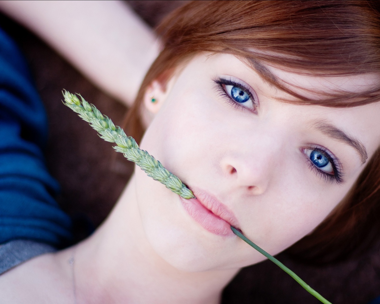 Зеленый колосок во рту у девушки