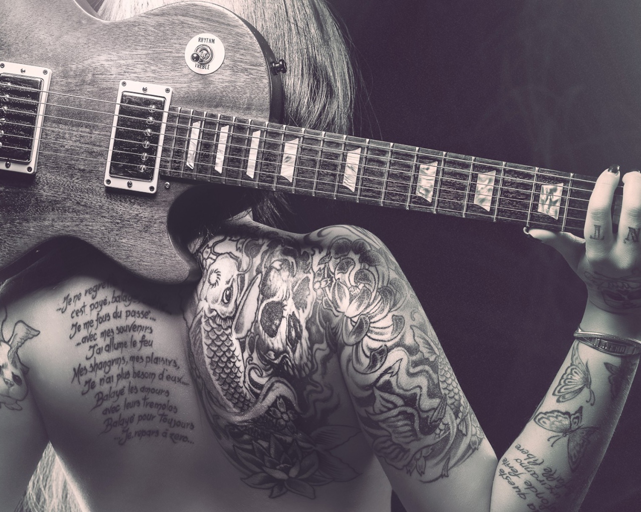 Guitar on his back tattooed girl
