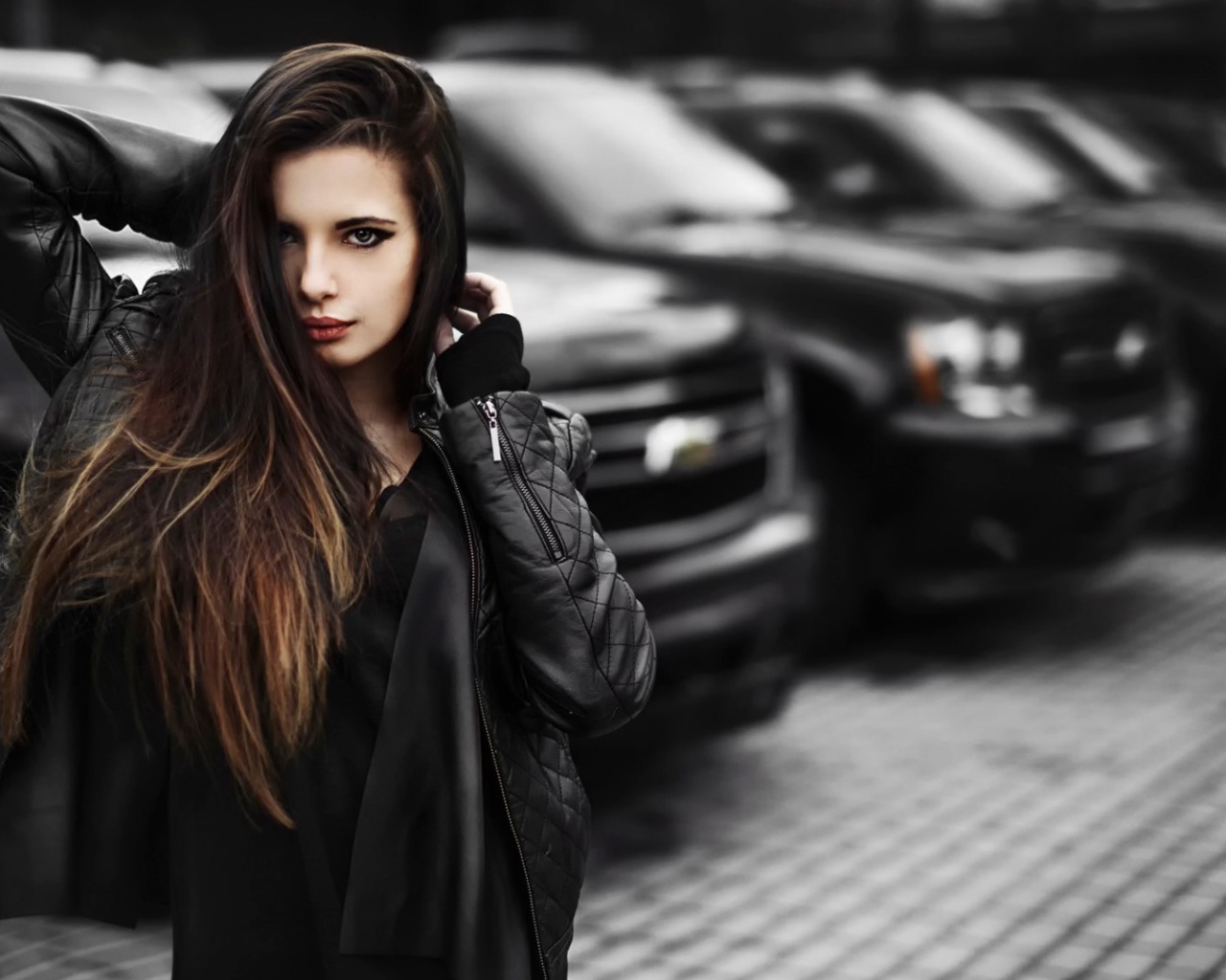 Черноволосая девушка на фоне черных автомобилей