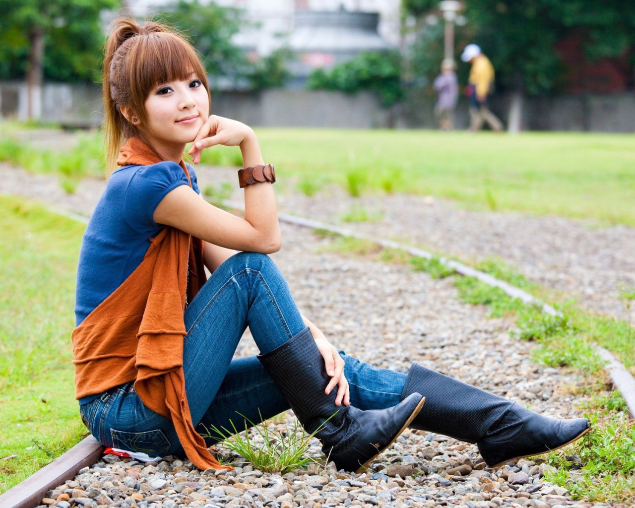 Японская девушка сидит на трамвайном пути