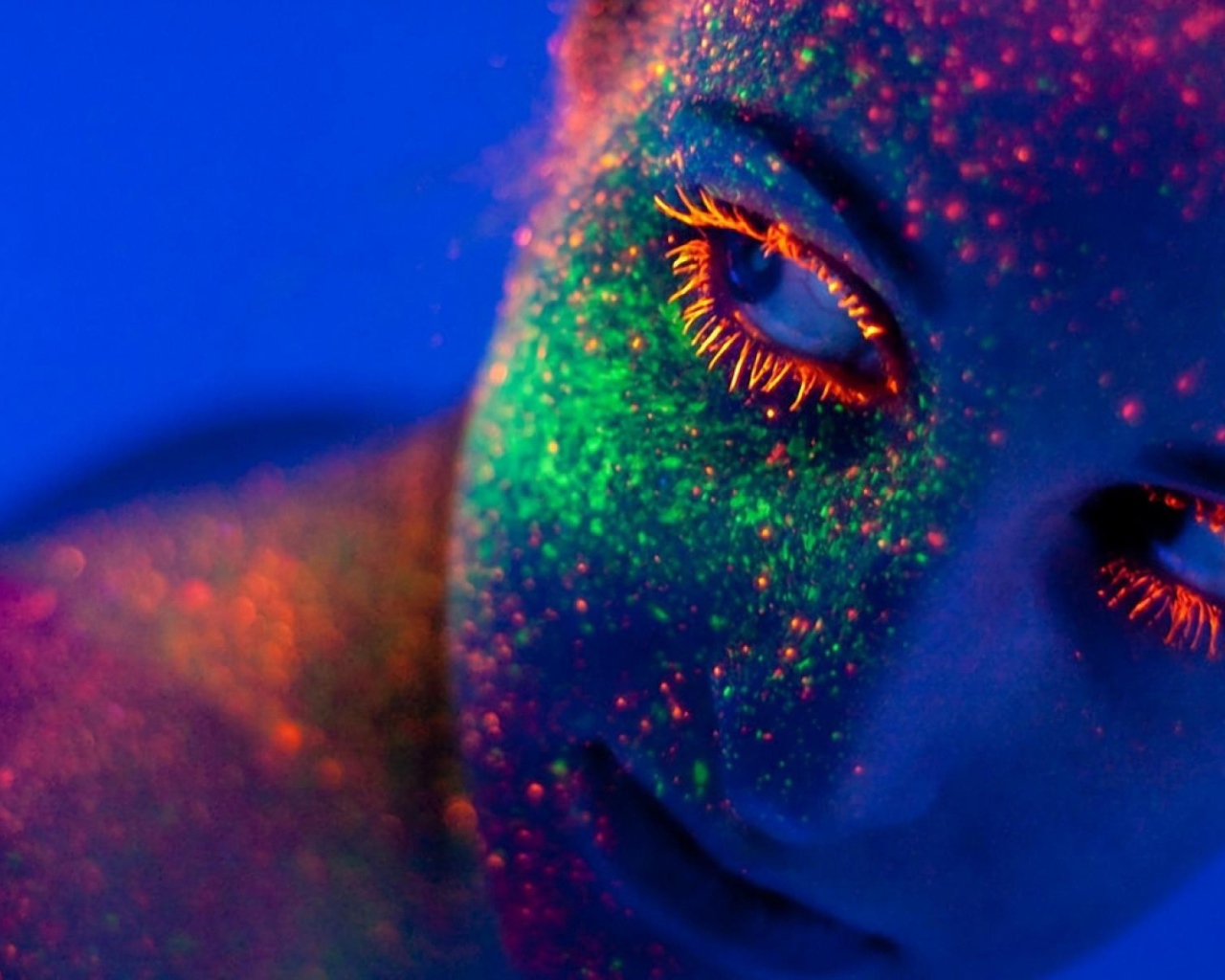 Неоновая краска на лице у девушки