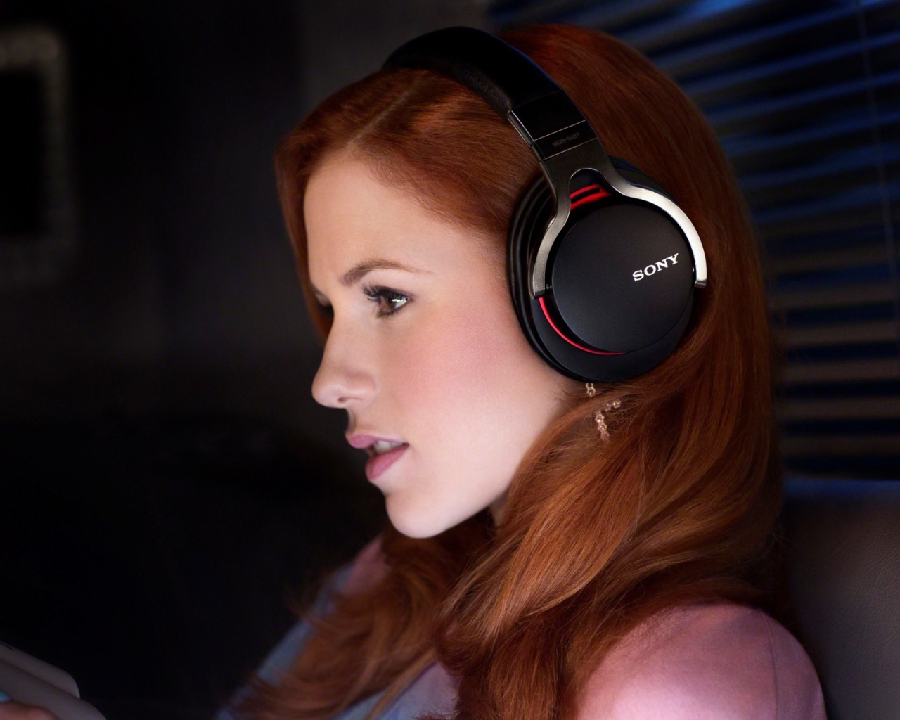 Рыжеволосая девушка слушает музыку