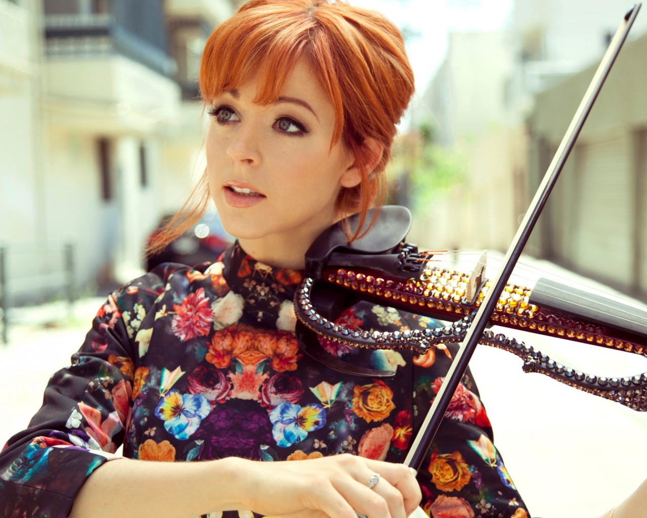 Рыжая девушка играет на скрипке со стразами
