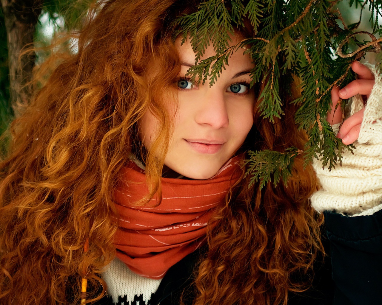 Рыжая девушка под ветками ели