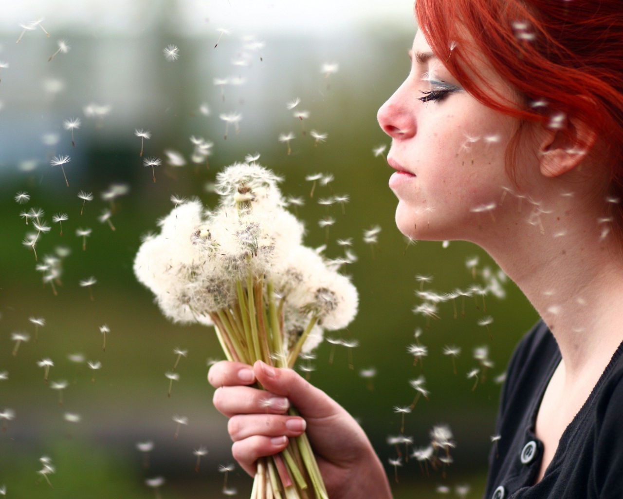 Рыжая девушка с букетом зрелых одуванчиков