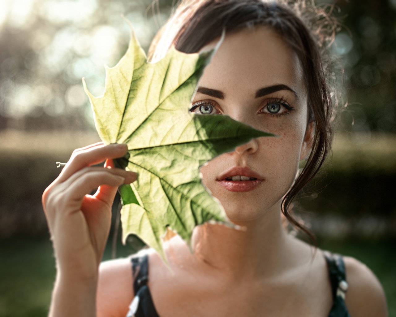 Девушка закрывает лицо листом, фото Георгий Чернядьев