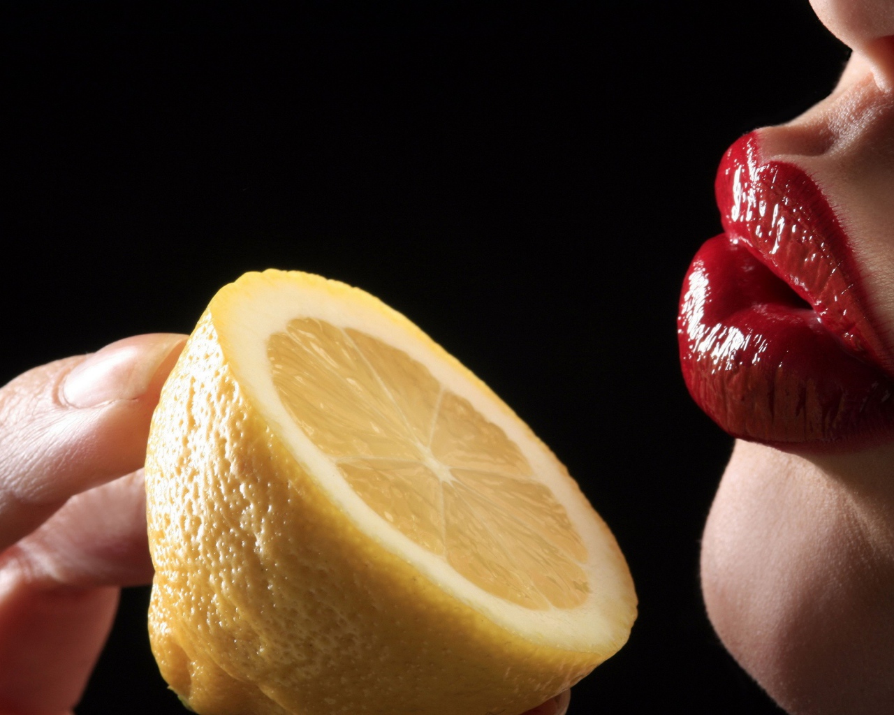 Девушка поднесла лимон к губам