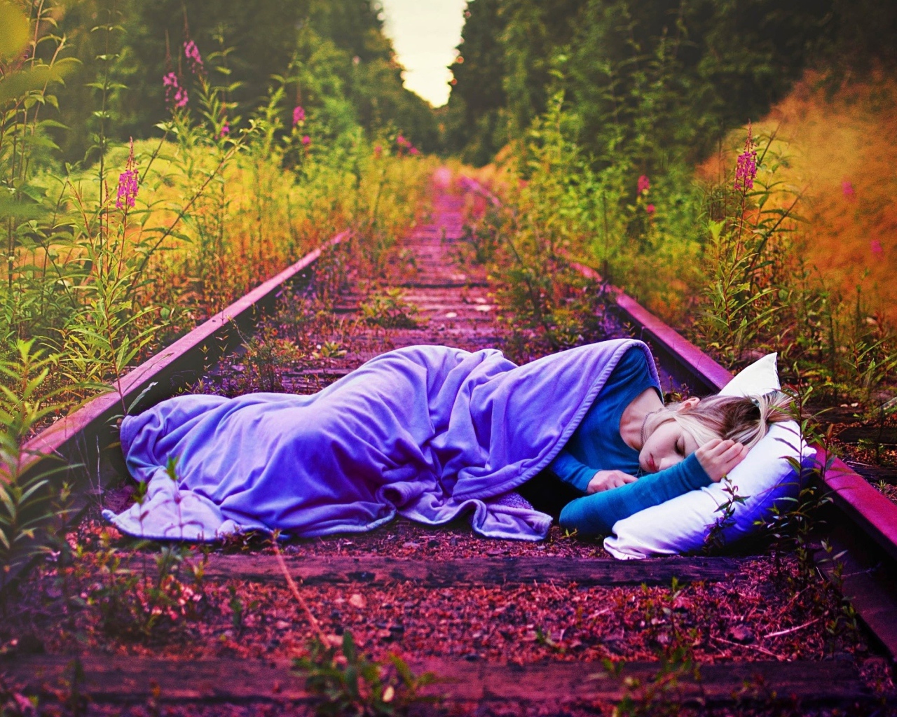 Девушка спит на заброшенных рельсах