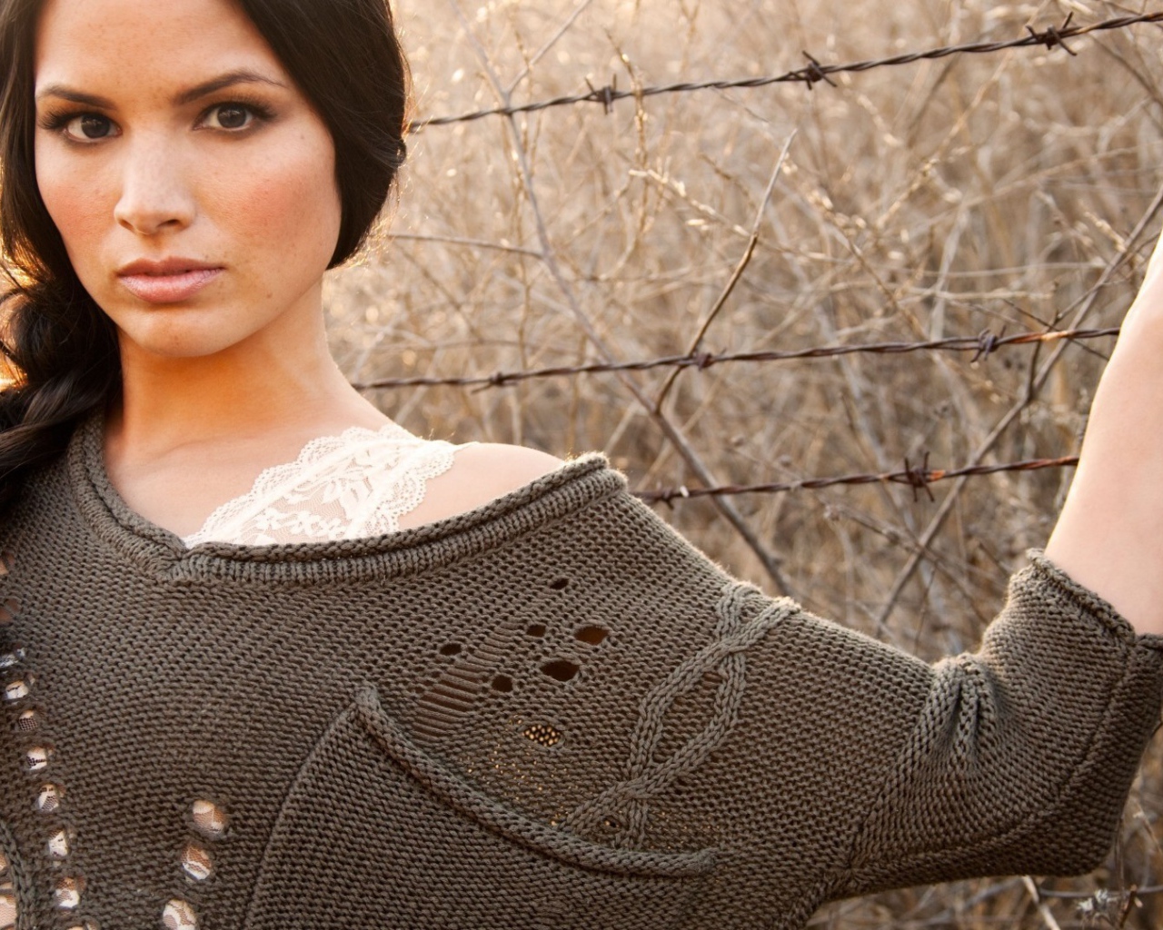 Девушка у забора из колючей проволоки