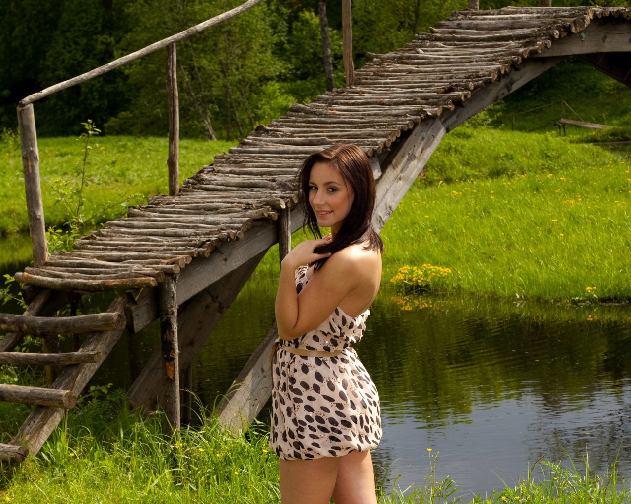 Девушка у деревянного моста через реку