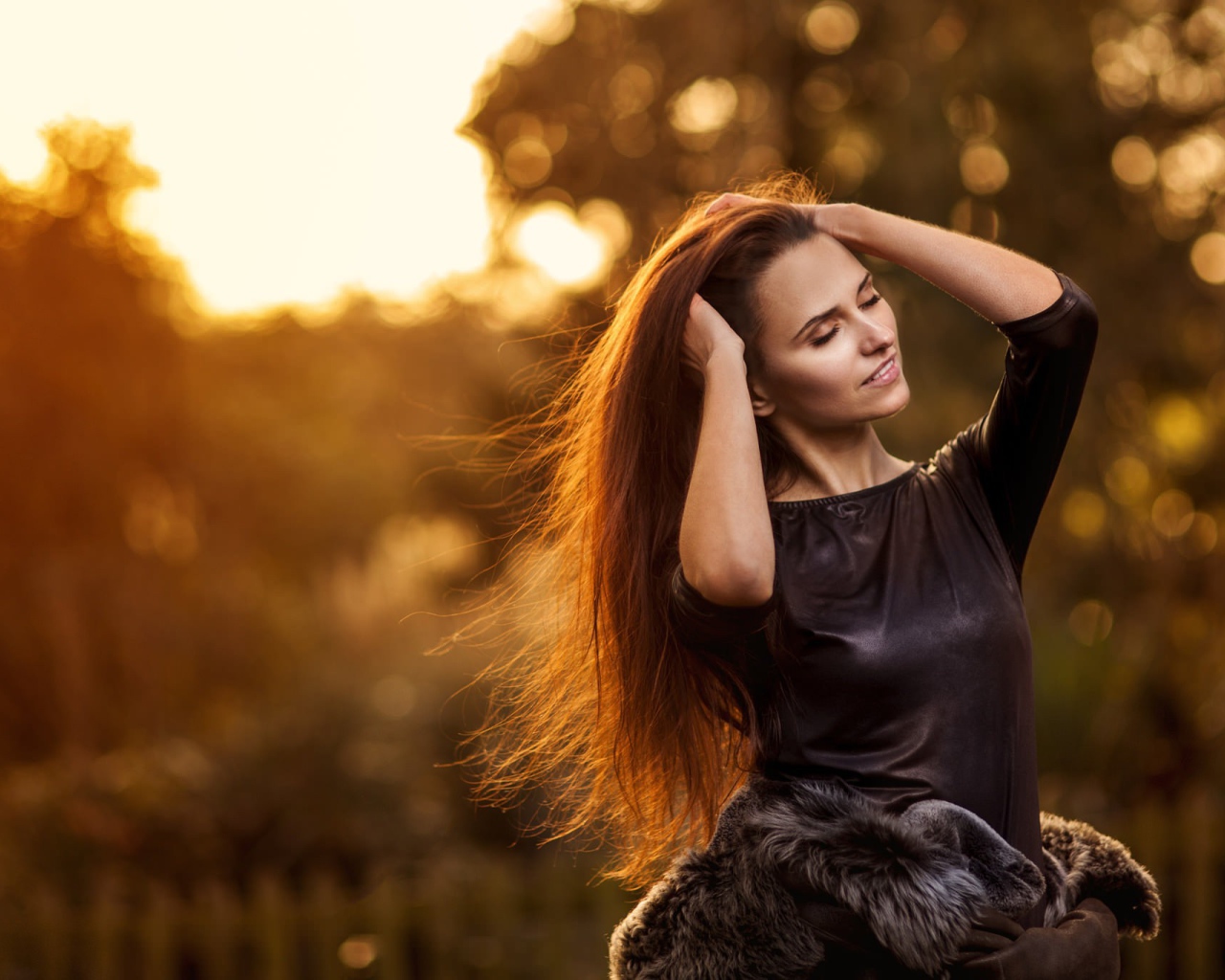 Девушка в черном платье поправляет прическу, портрет