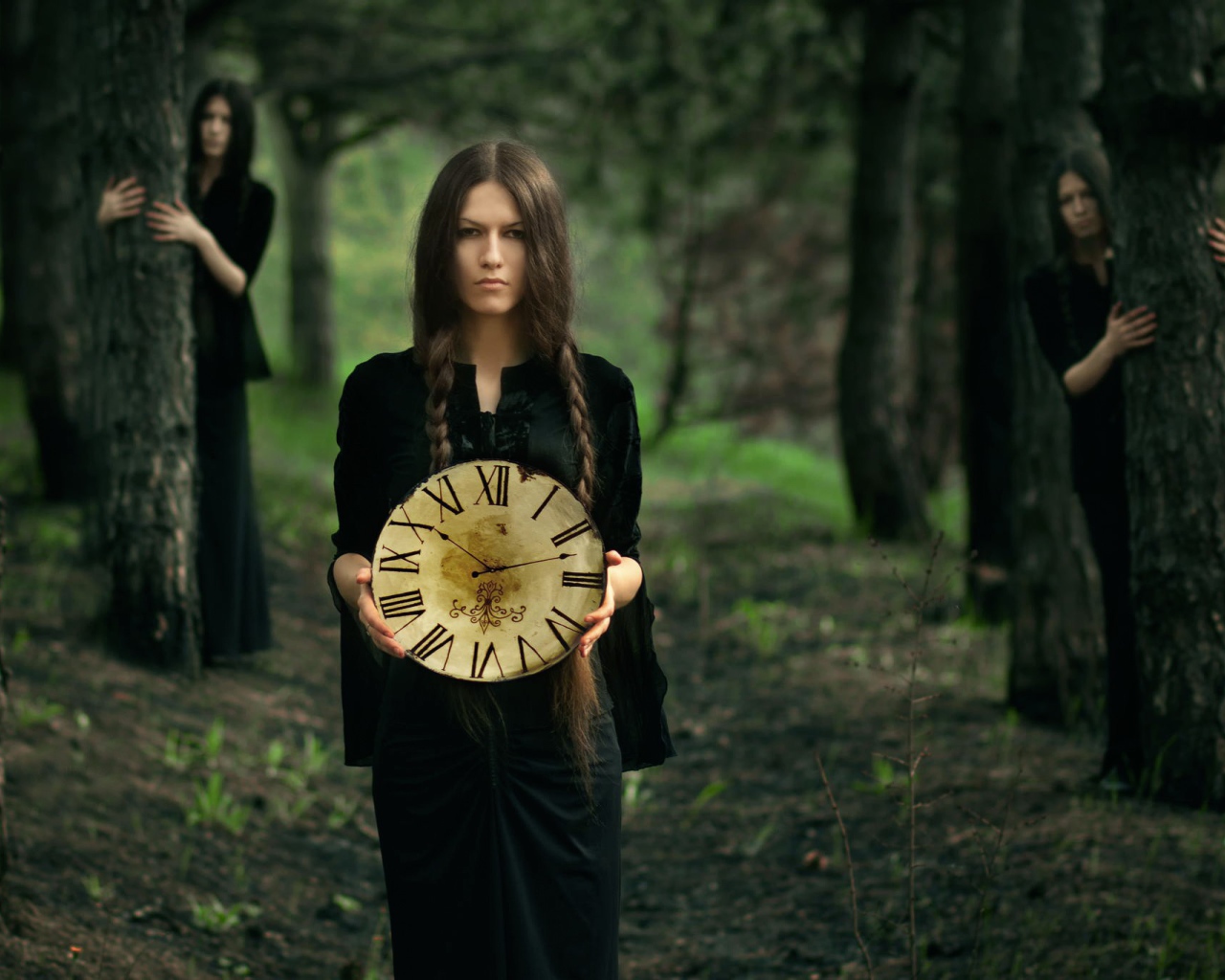 Девушка в черном платье держит часы в руках