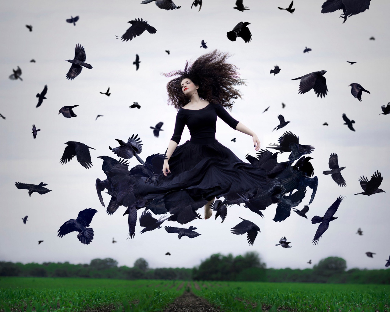 Девушка в черном платье парит среди ворон