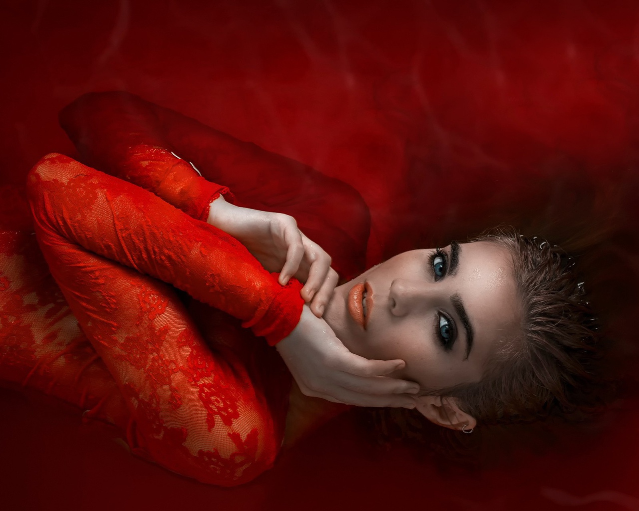 Девушка в красном кружевном платье на красном фоне