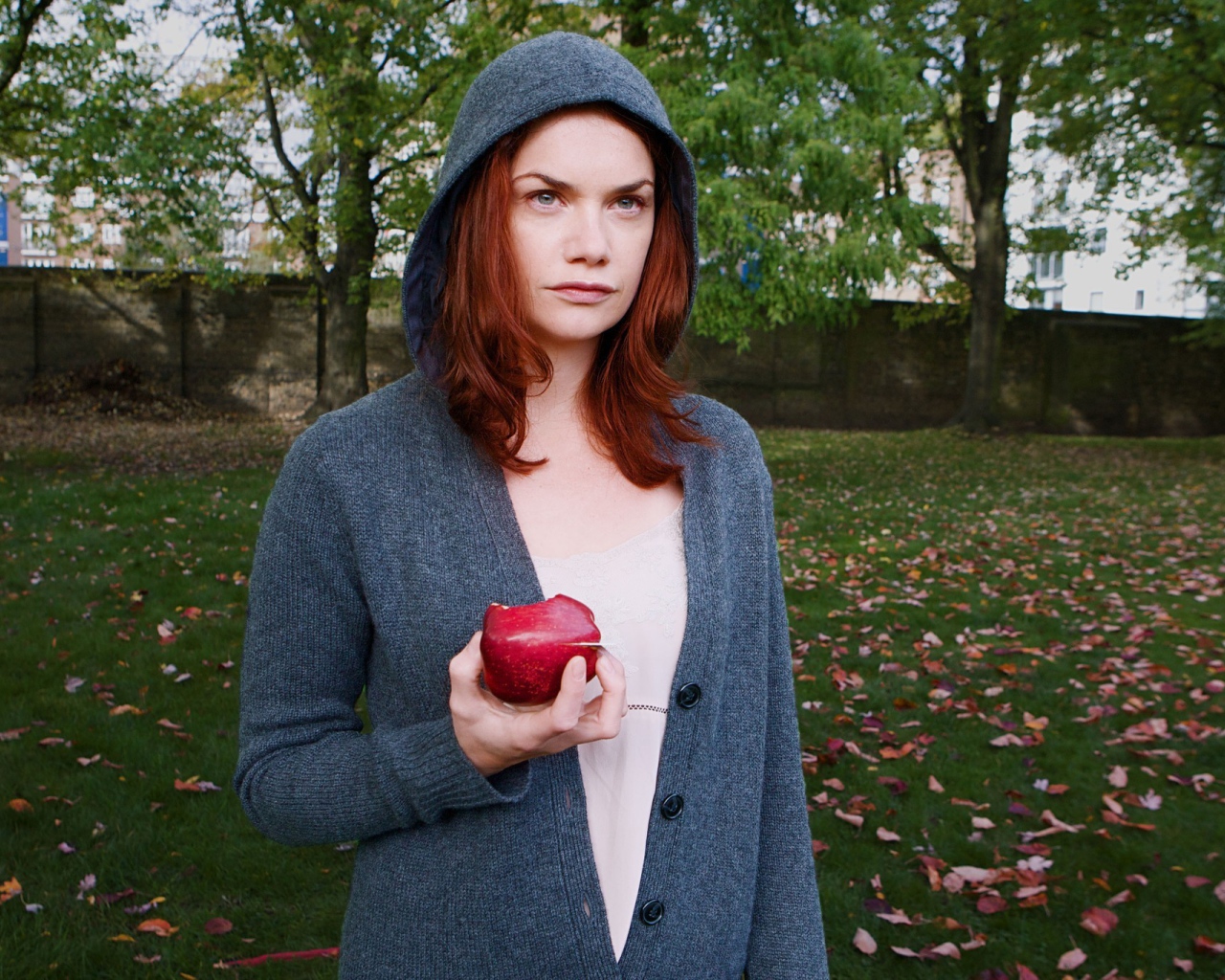 Девушка в капюшоне с яблоком