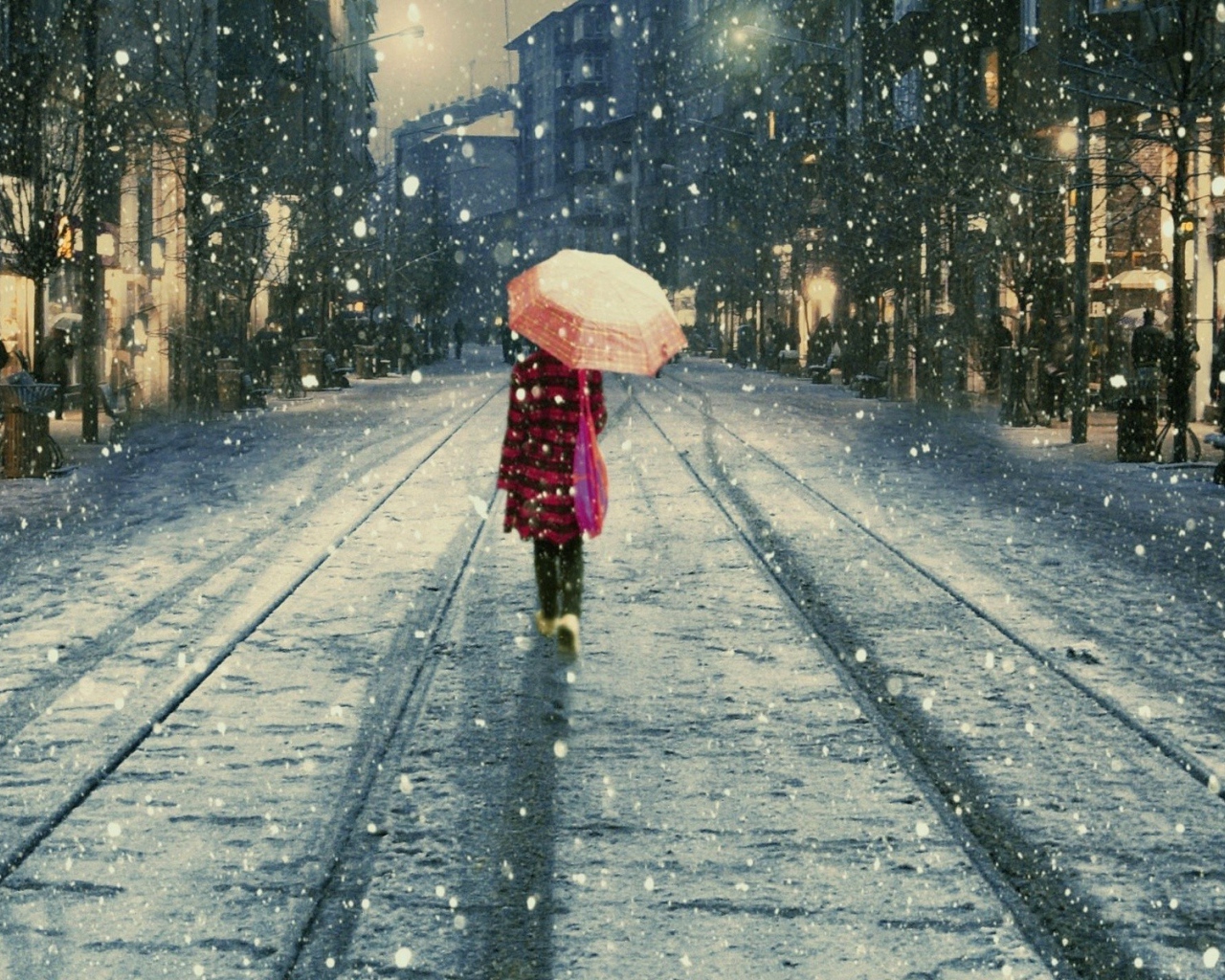 Девушка под дождем идет вдаль по улице