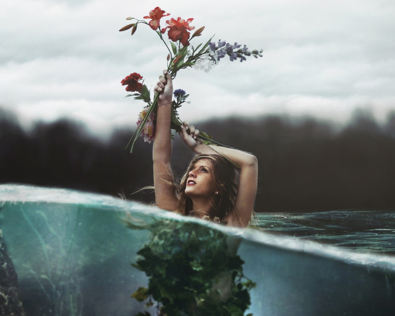 Девушка в воде стоит вытянув руку с букетом