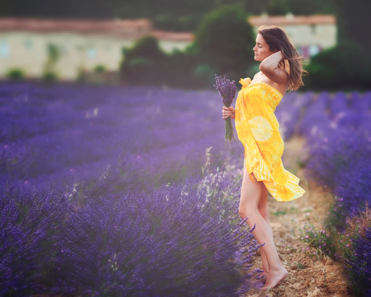 The girl in yellow pareo with a bouquet of lavender on field