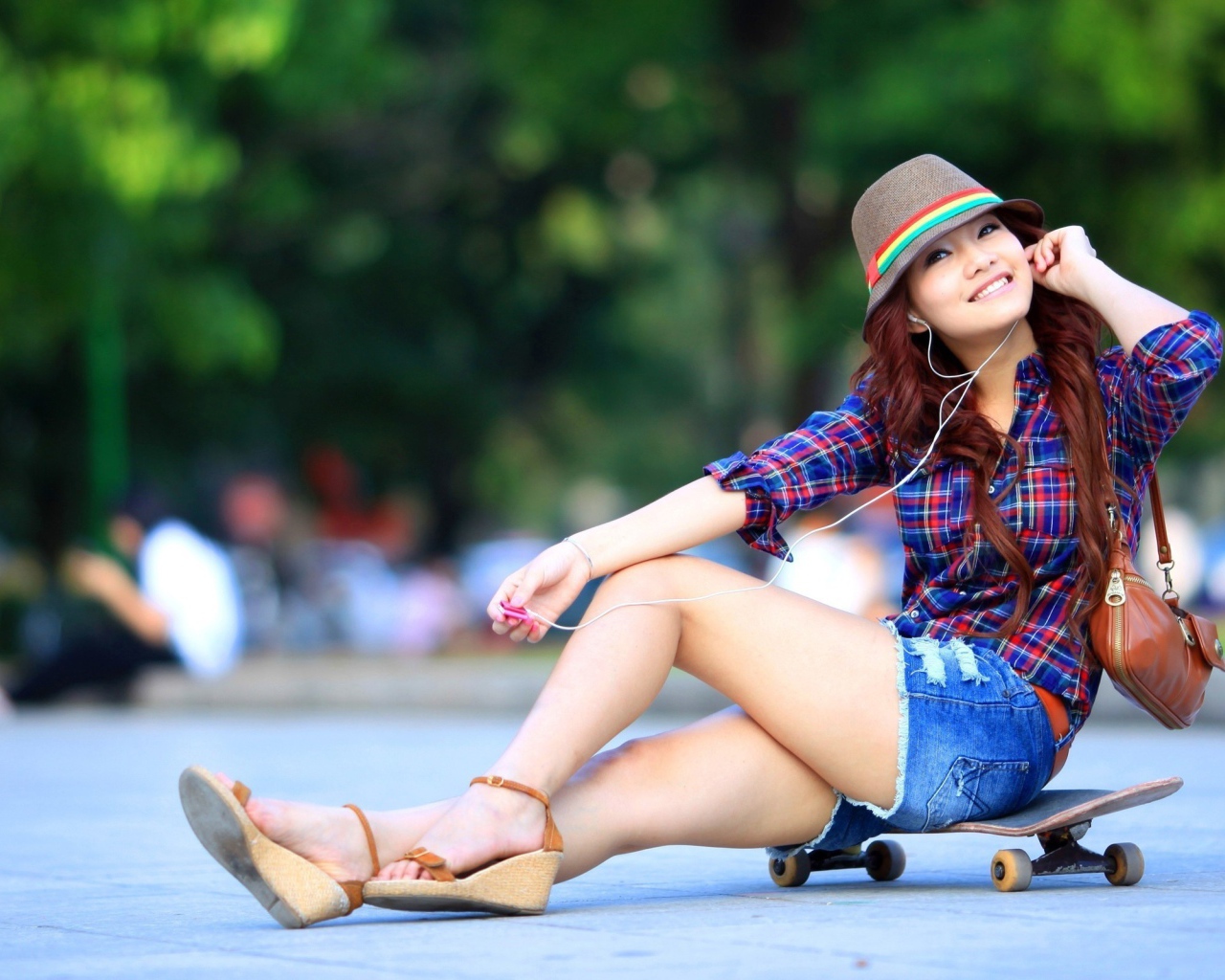 Девушка сидит на скейтборде